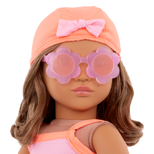 A close up of an Our Generation Doll wearing the Deluxe Outfit "Floaty Fun", including a bathing cap and sunglasses