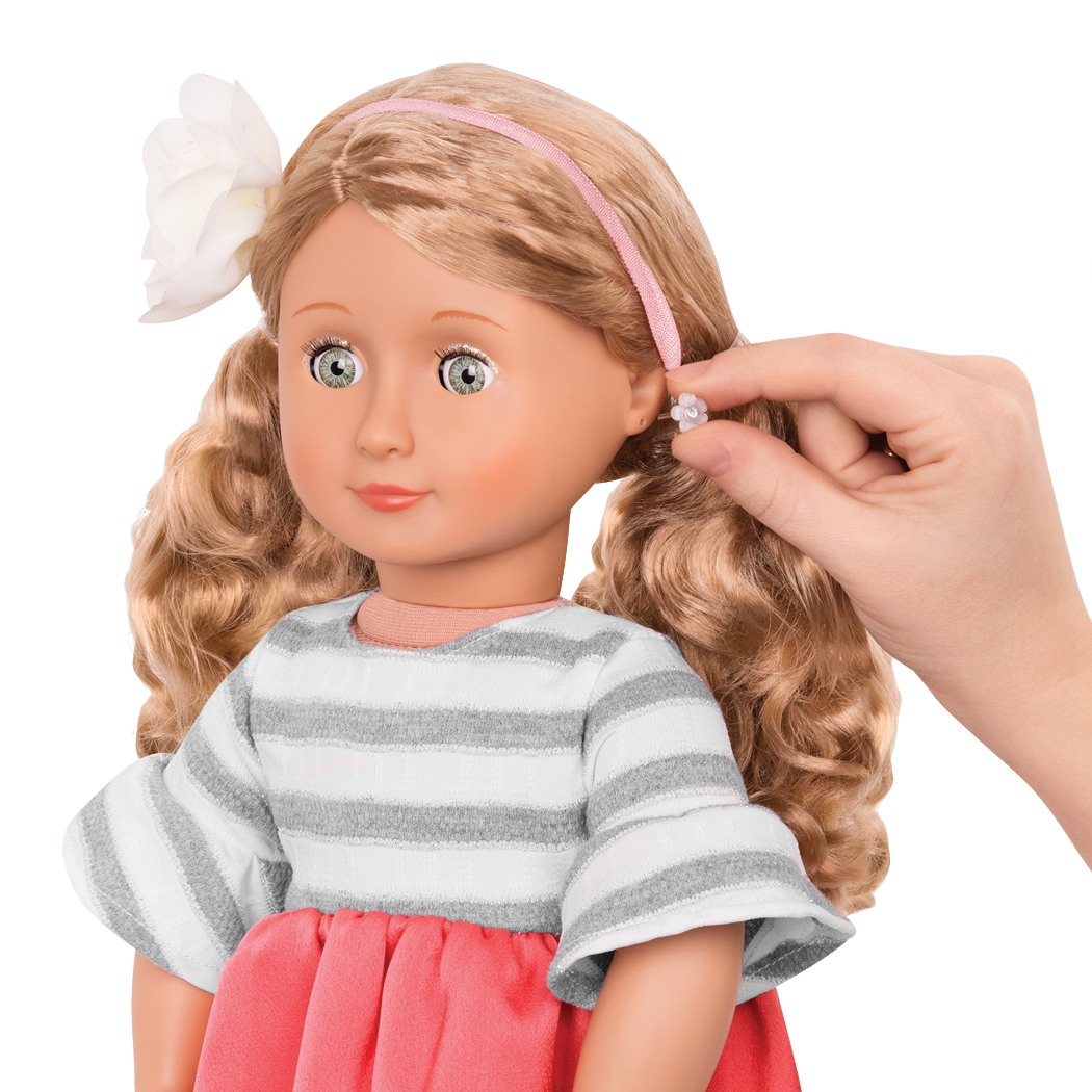 Close up of adding earrings to doll
