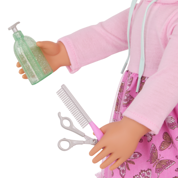 Our Generation Doll Hattie Holding Pet Grooming Accessories in Hands