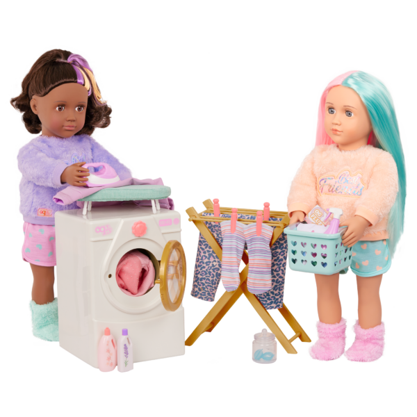 One OG Doll ironing clothes and another OG Doll carrying laundry, with washing machine and laundry products