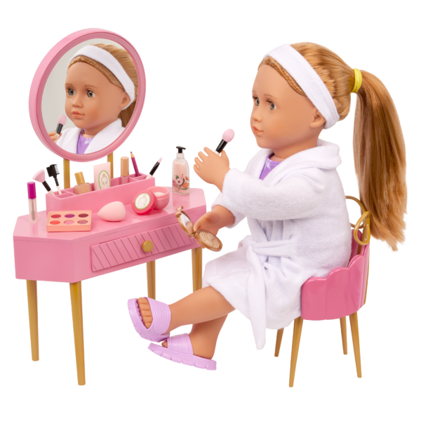 Our Generation 18 inch Doll sitting at the vanity table applying make up